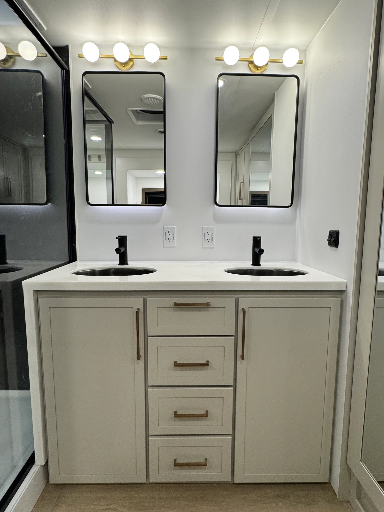 Two sinks and separate mirrors above drawers and cabinets in the Aurum's front bathroom.
