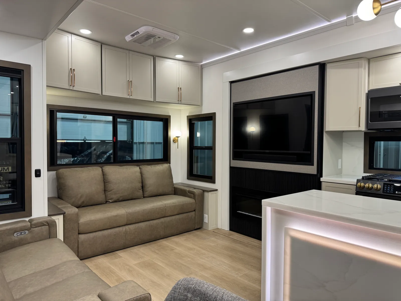 Rear living area with a leather sofa under the windows and the entertainment wall beside it.