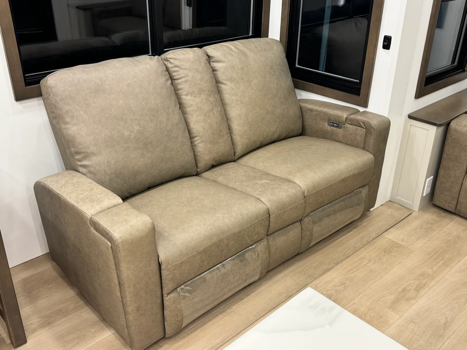 Close view of the taupe leather sleeper sofa.