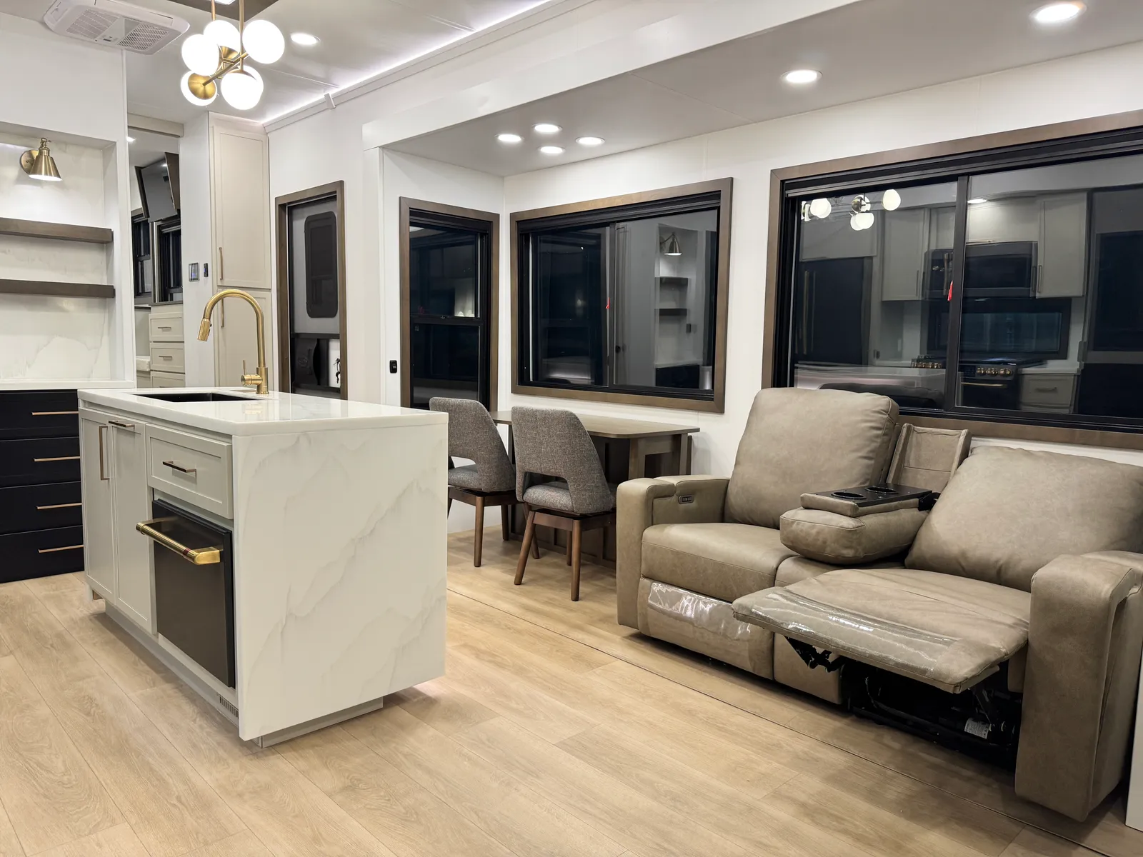 View from the theater seats toward the kitchen island, dining table and side windows.