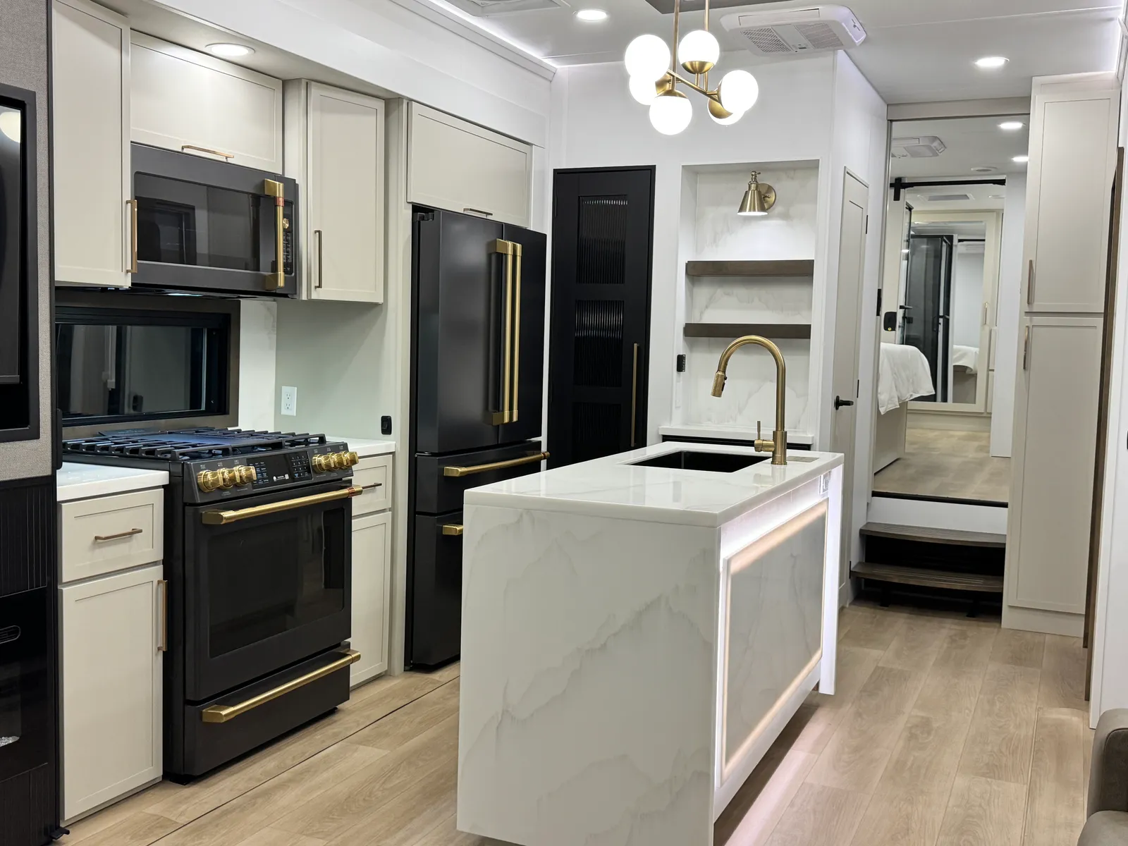 Kitchen with the range, refrigerator and island, looking toward the steps up to the bedroom.