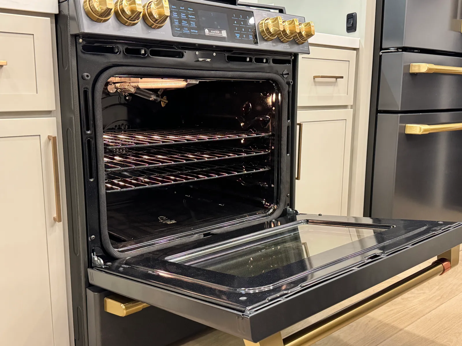 The range's oven door open, showing the racks inside.