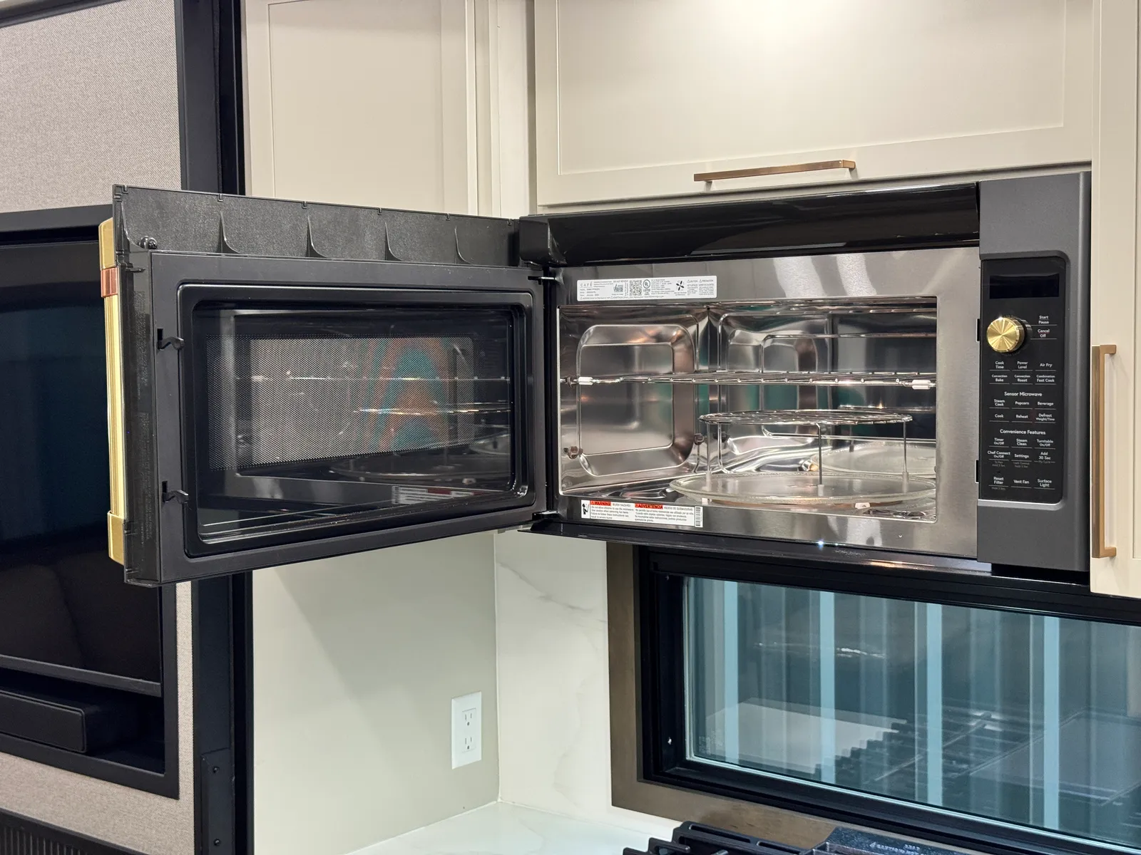 The microwave door open, showing its stainless interior.