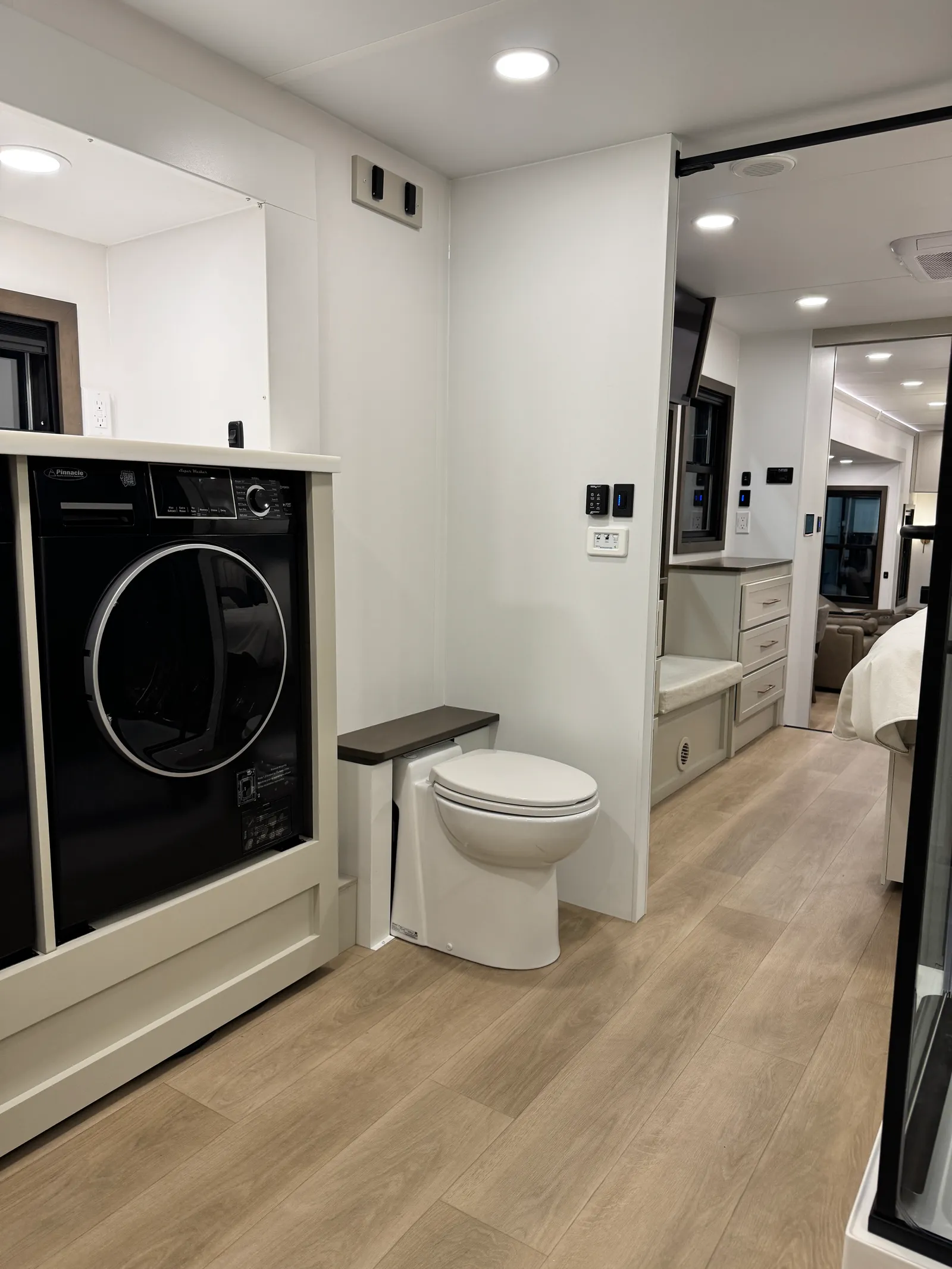 The front bath's toilet beside the washer and dryer cabinet.
