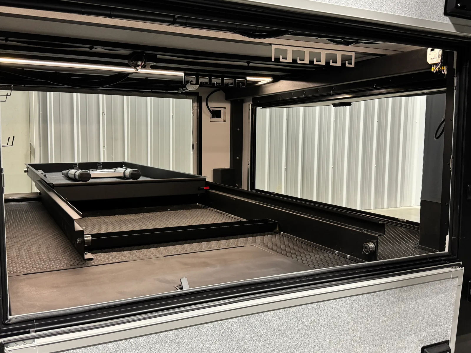 Open pass-through storage bay with a tray partly extended.