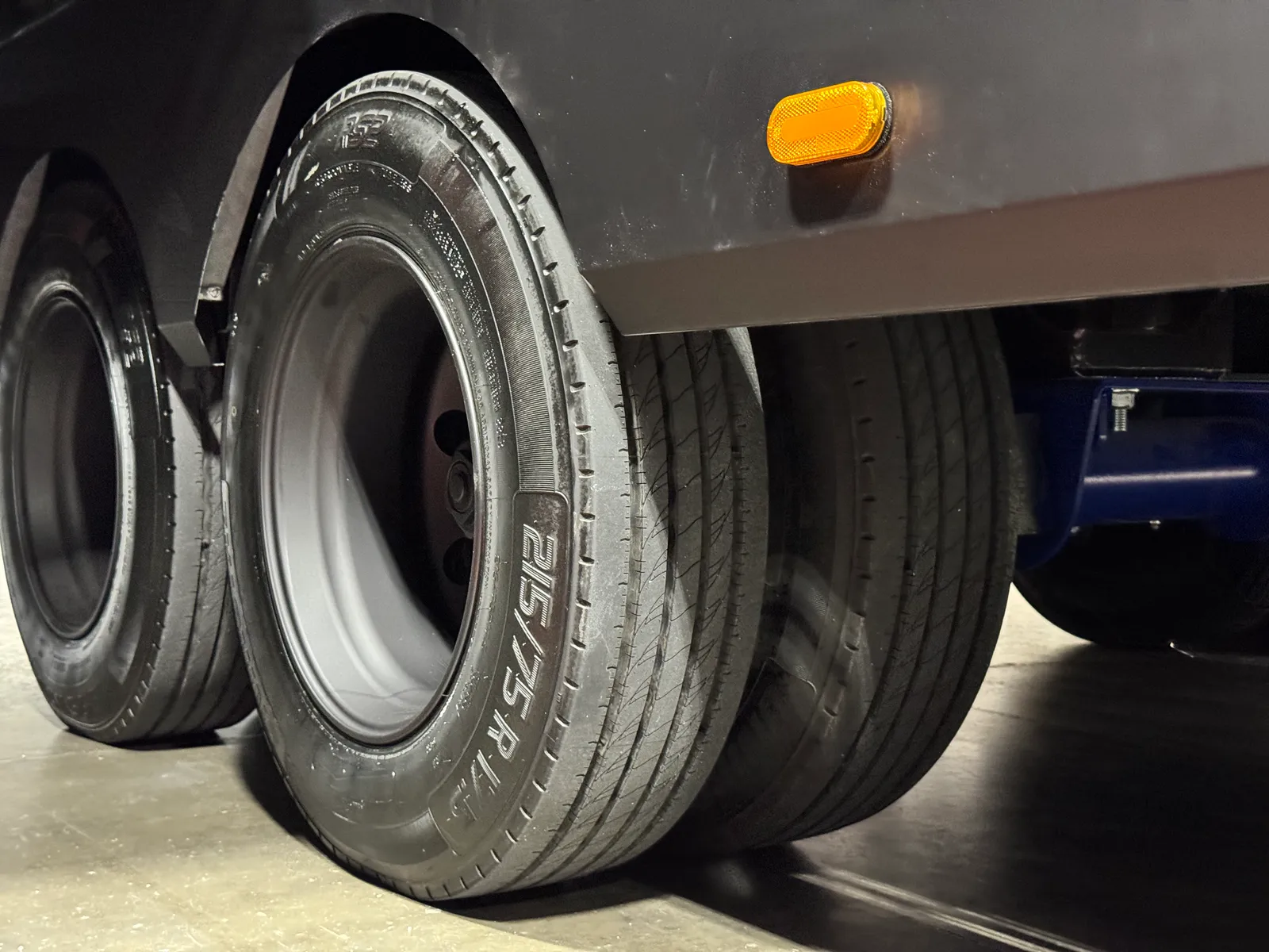 Close view of the Aurum's dual rear wheels and tires below the black sidewall.