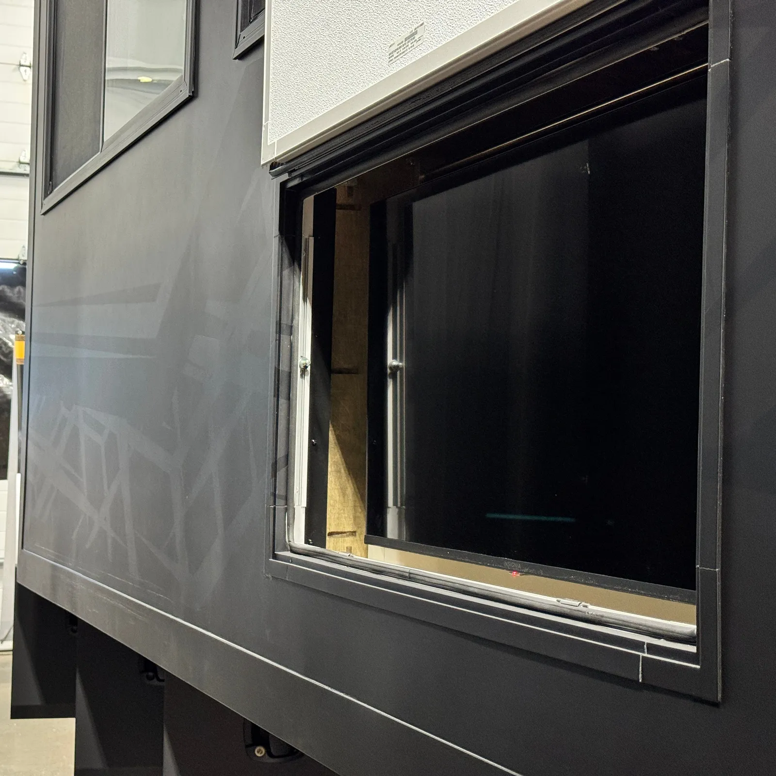 An open compartment in the black side of a slide-out, below a white panel.