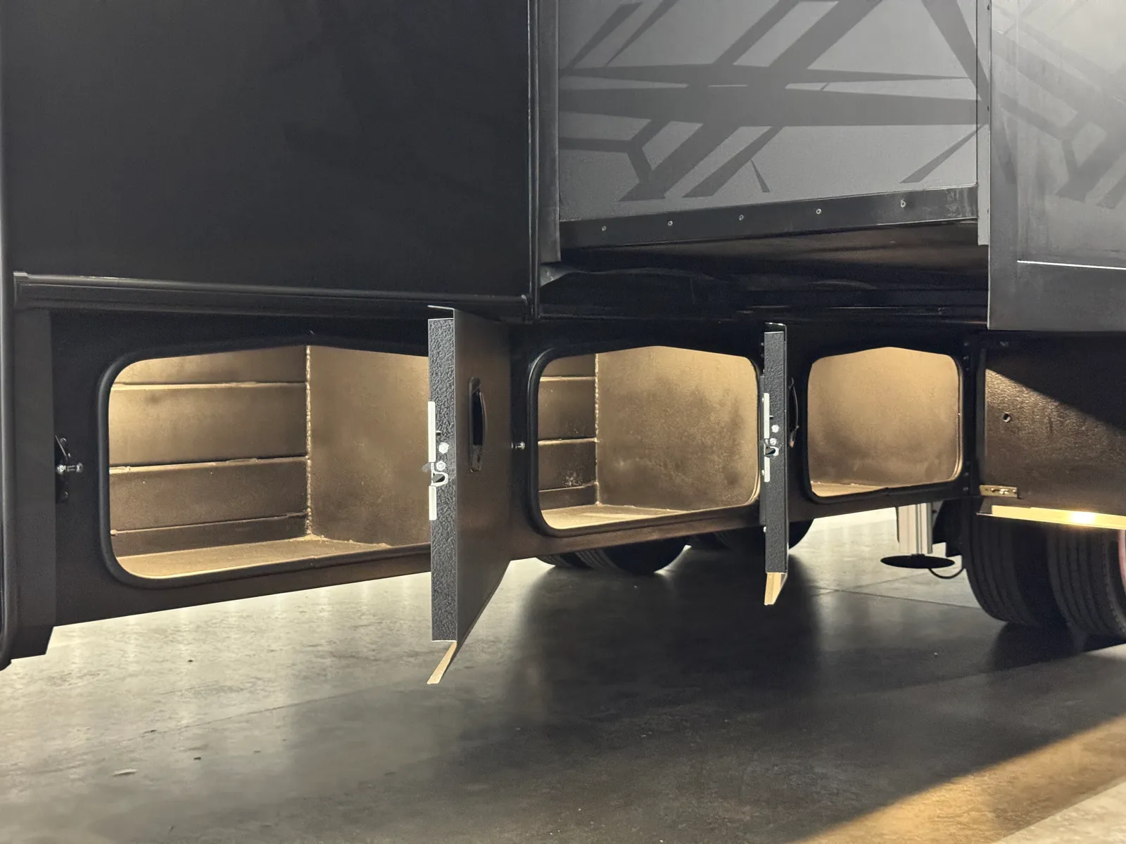 Three lit storage compartments open beneath the coach along the chassis.