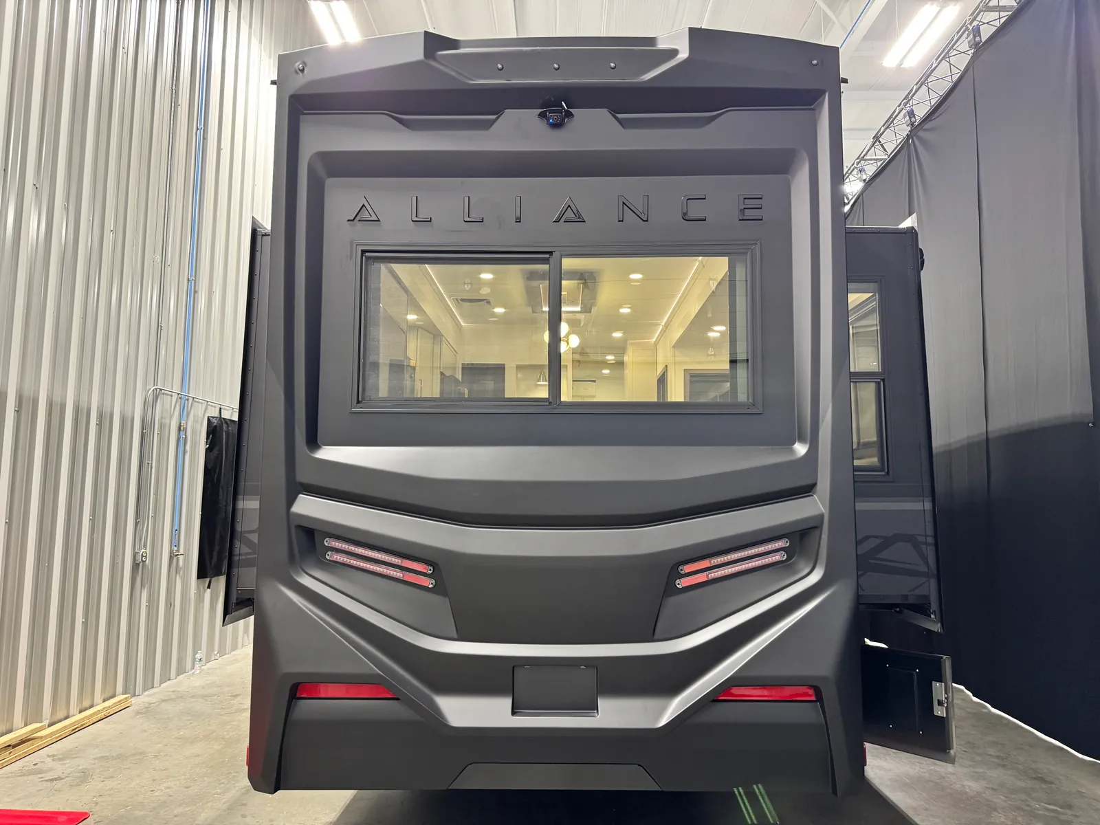 Straight-on rear view of the Aurum showing the rear window, ALLIANCE lettering and red light bars.