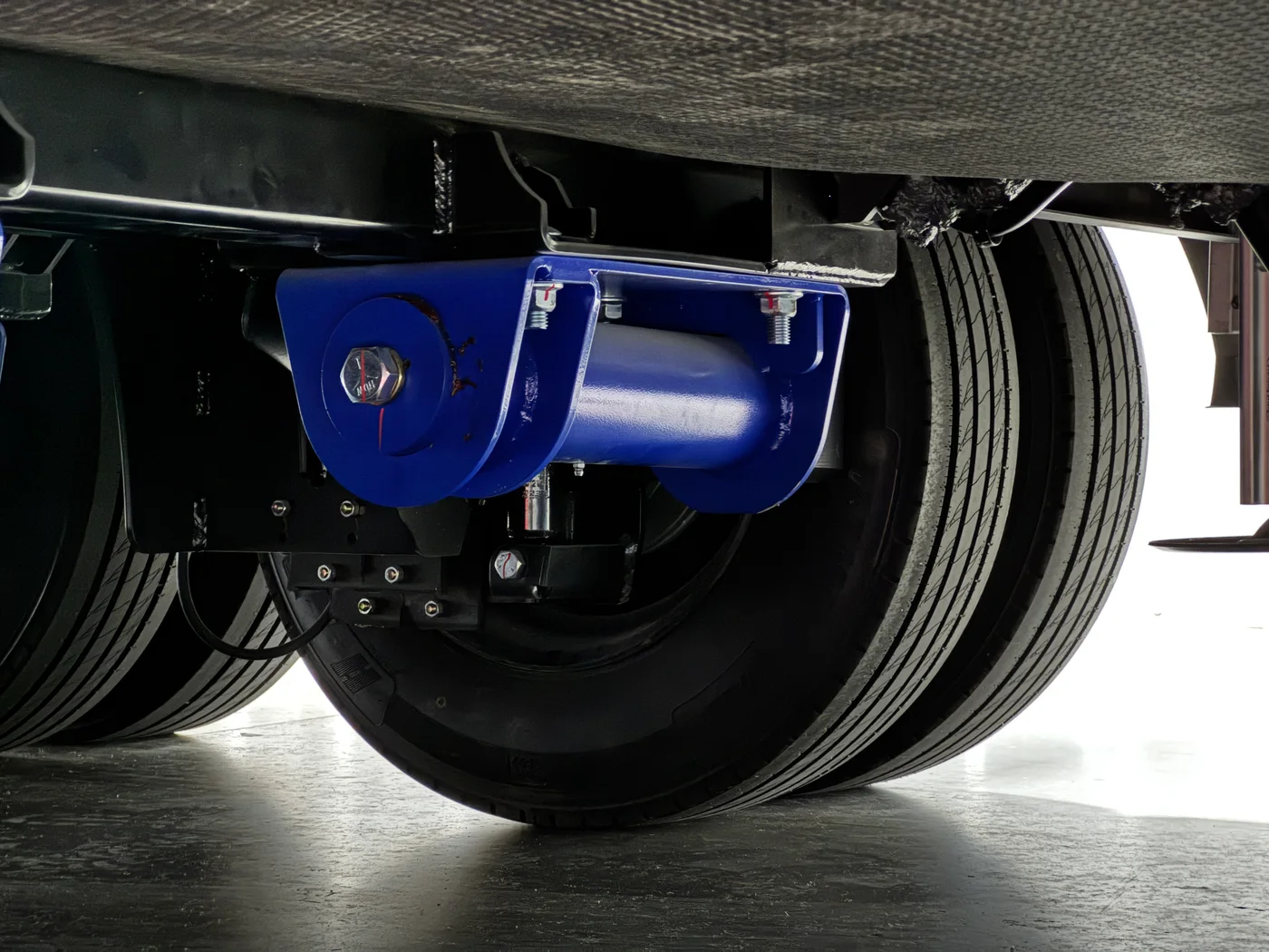 Underside of the Aurum showing the frame rails and a blue suspension component above the dual rear tires.